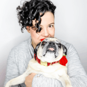 Image of Amanda with Bunny the fawn pug dog wearing a glitter velvet collar in red with rose